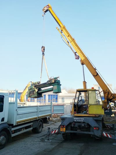 Autojeřáb Praga V3S AD080 nakládá stroj na nákladní automobil